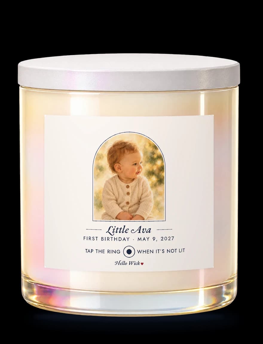 A Hello Wick candle labelled Little Ava, first birthday May 9 2027, with a watercolour of the baby in an arch